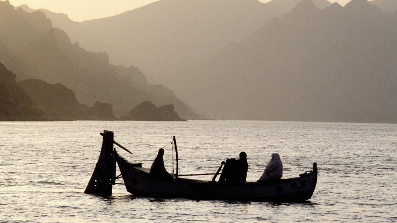 Silhouetted boat on calm water