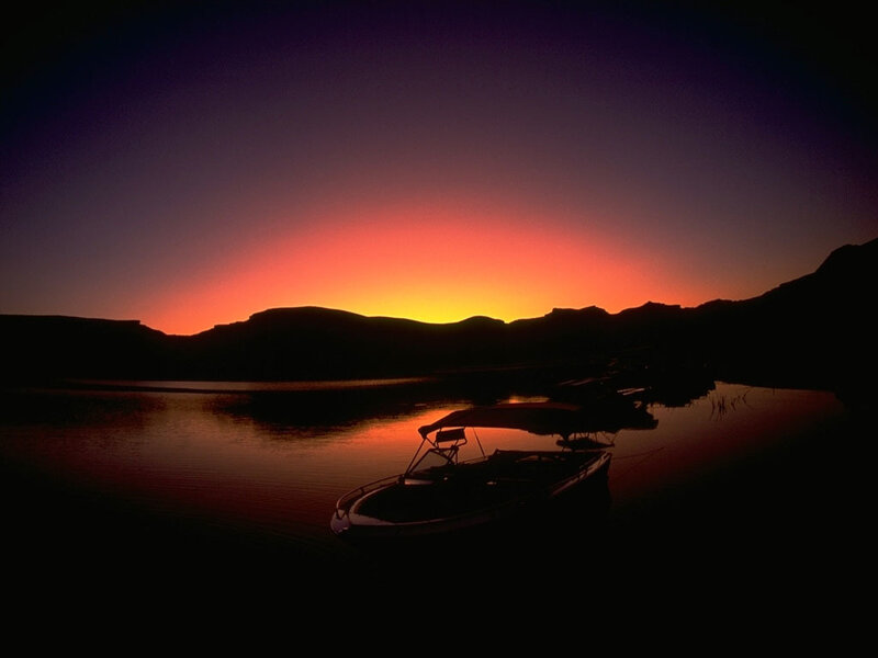 Silhouetted Boat on Lake — Orange, Serene, Sunset
