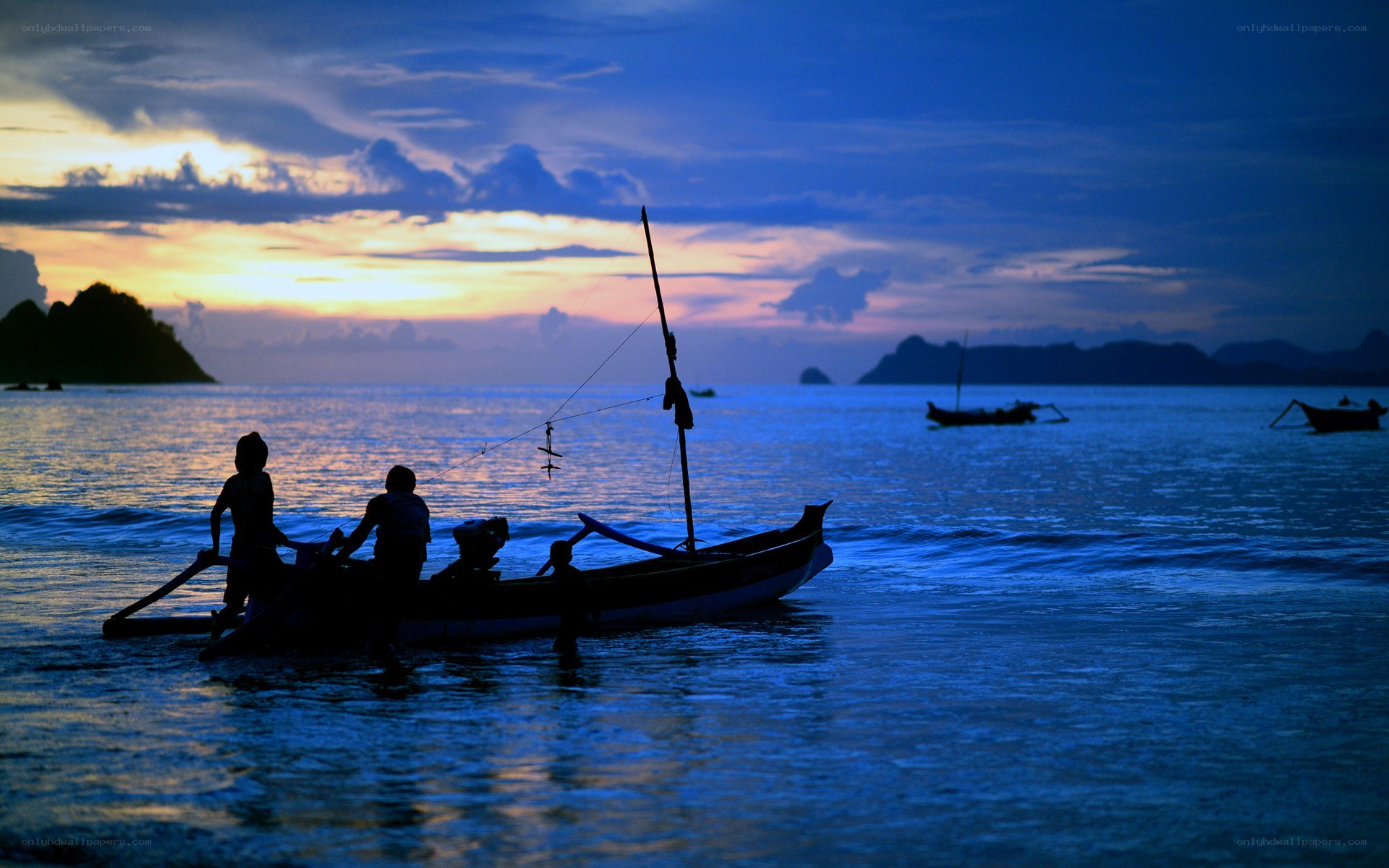 Silhouetted boats at sunset