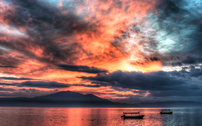 Silhouetted Boats at Sunset — Orange, Dramatic, Photograph, Mountain