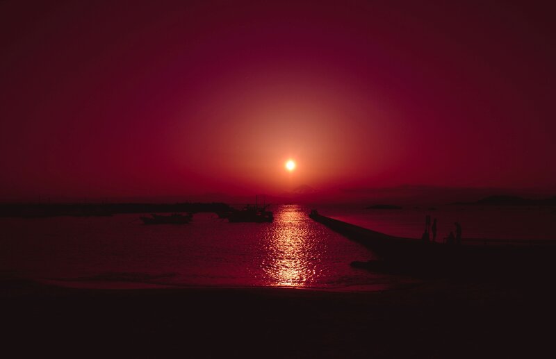Silhouetted Boats at Sunset — Red, Dramatic, Photograph