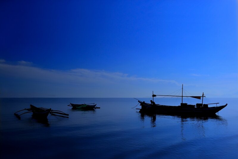 Silhouetted Boats on Water — Blue, Serene, Sunset