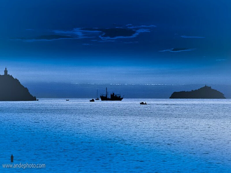 Silhouetted Boats on Water — Blue