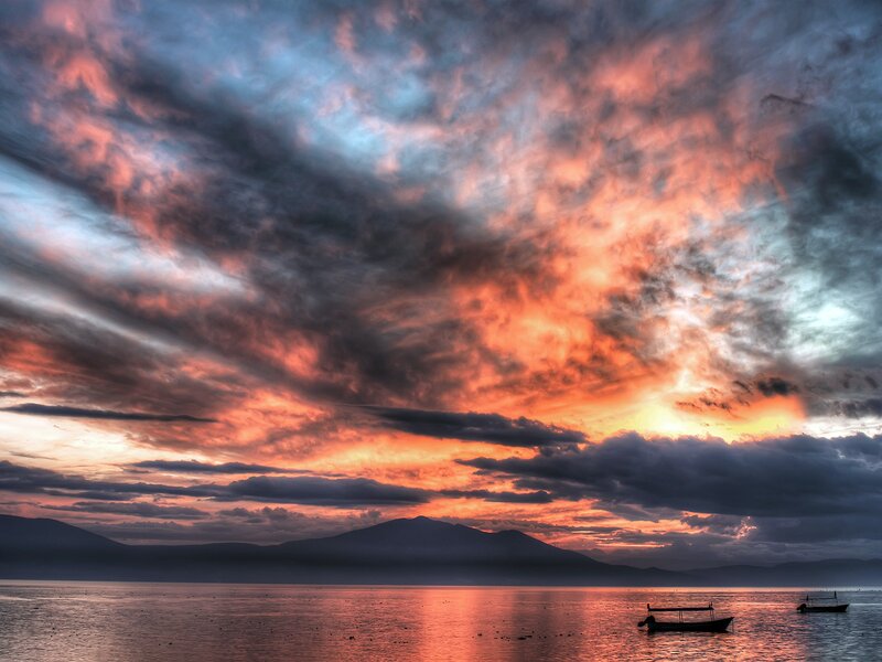 Silhouetted Boats on Water — Orange, Dramatic, Sunset, Photograph, Mountains, Sky