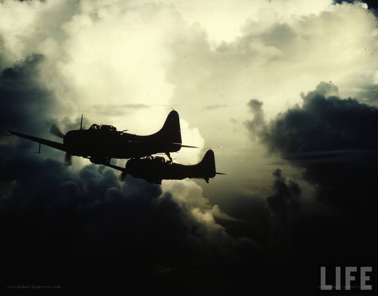 Silhouetted bombers in cloudy sky