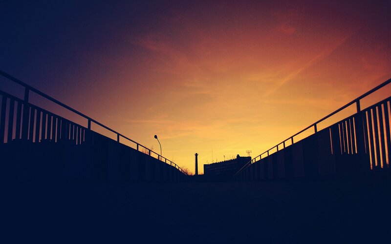 Silhouetted Bridge at Sunset — Orange, Dramatic, Photograph