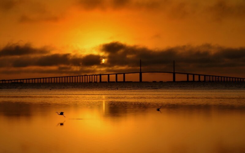 Silhouetted Bridge at Sunset — Orange, Serene, Photograph