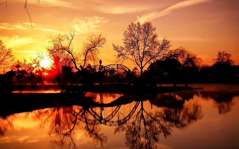 Silhouetted Bridge at Sunset — Orange, Serene