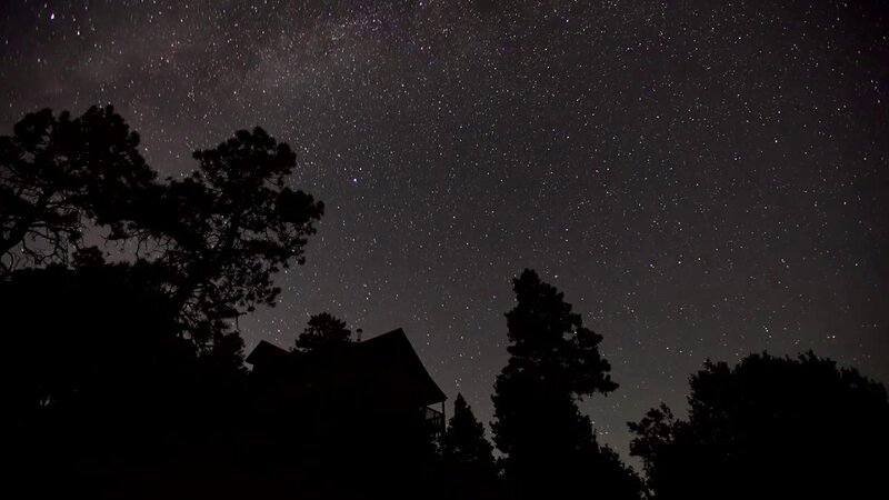 Silhouetted Cabin under Stars