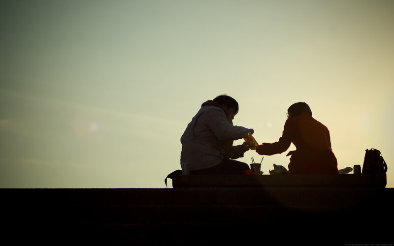 Silhouetted couple sharing a drink