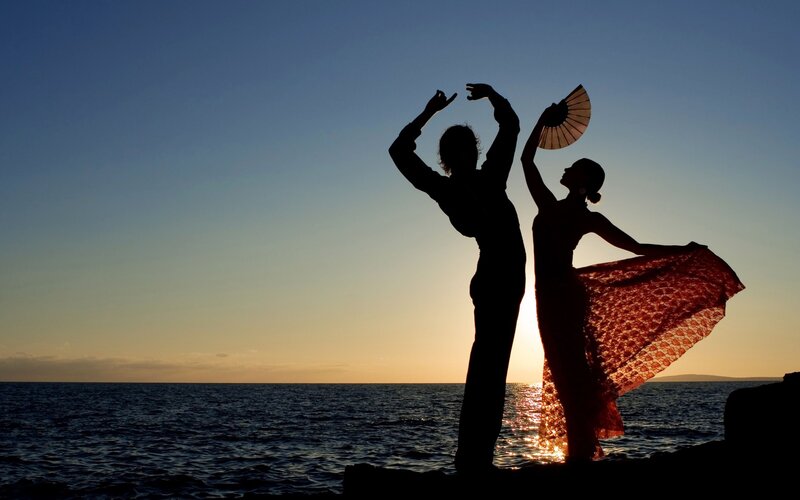 Silhouetted Dancers on Shore