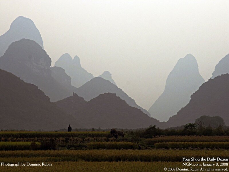 Silhouetted farmers in karst landscape