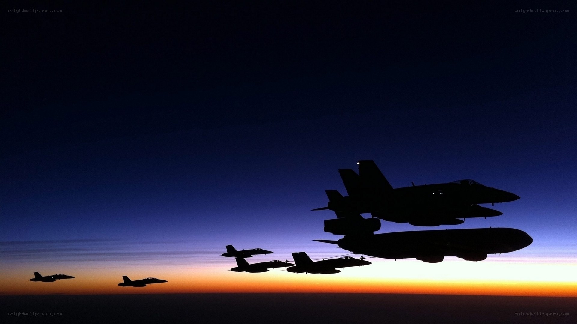 Silhouetted fighter jets at dusk
