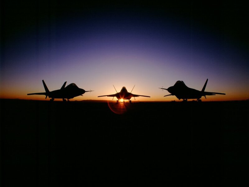 Silhouetted fighter jets at sunset
