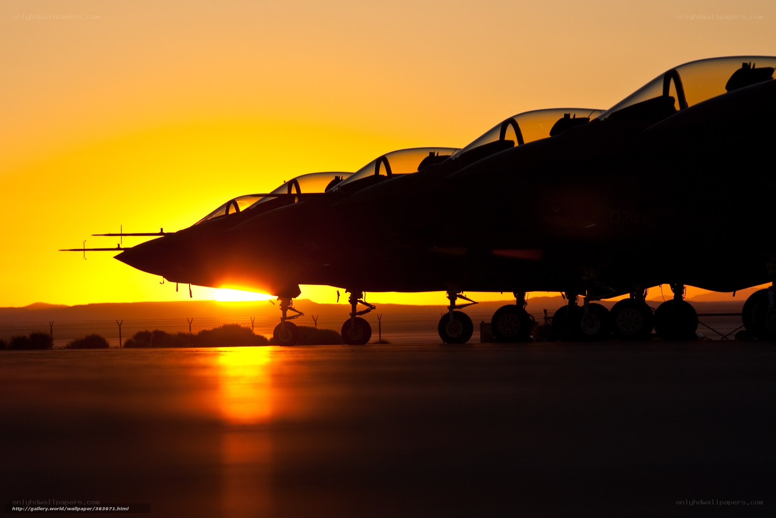 Silhouetted fighter jets at sunset