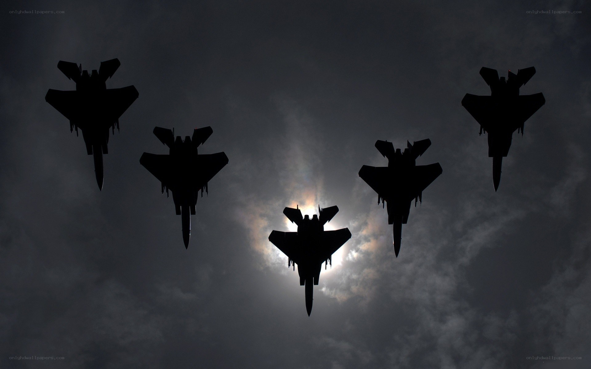 Silhouetted fighter jets in formation