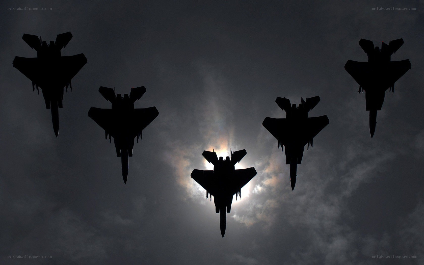 Silhouetted fighter jets in formation