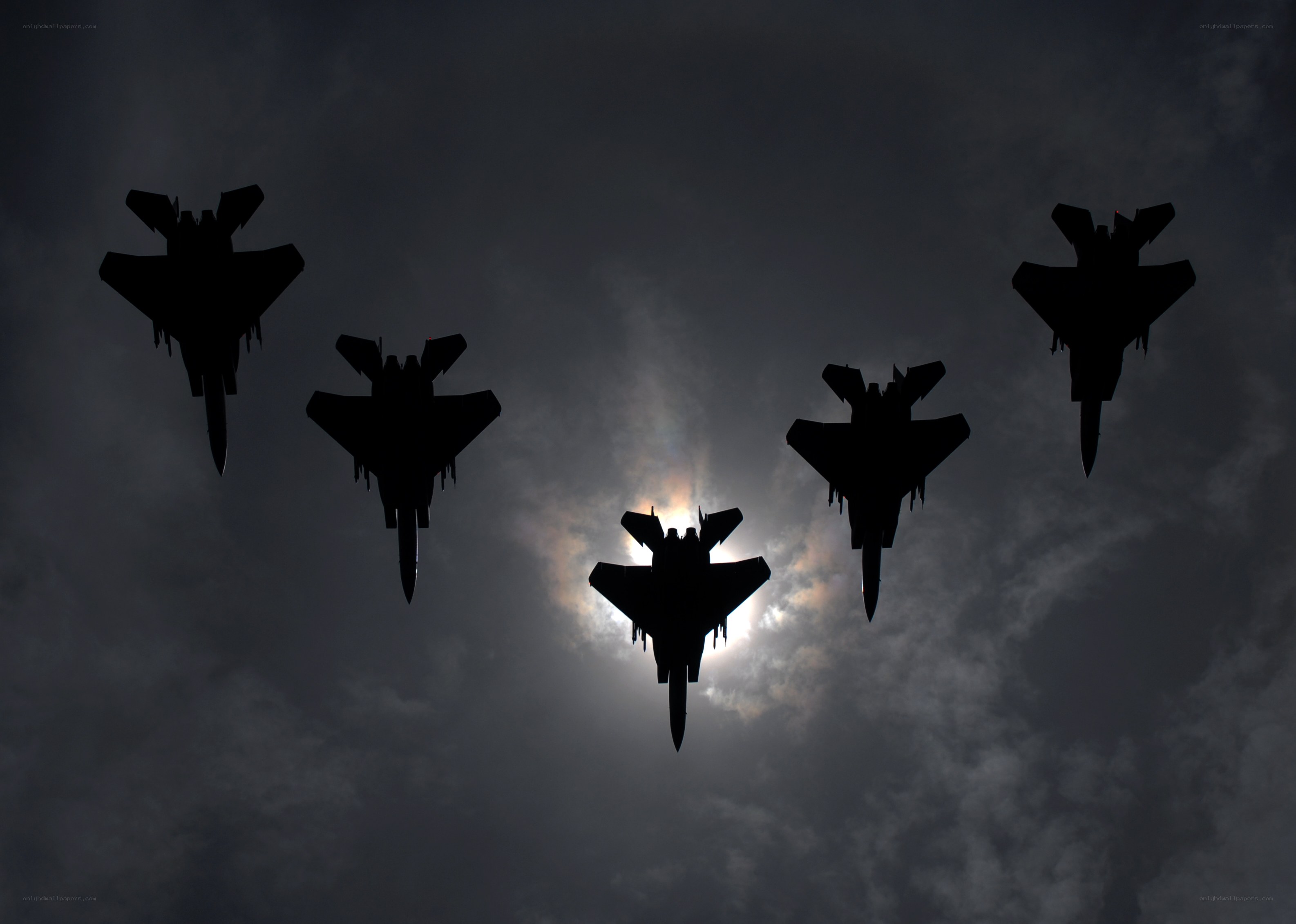 Silhouetted fighter jets in formation