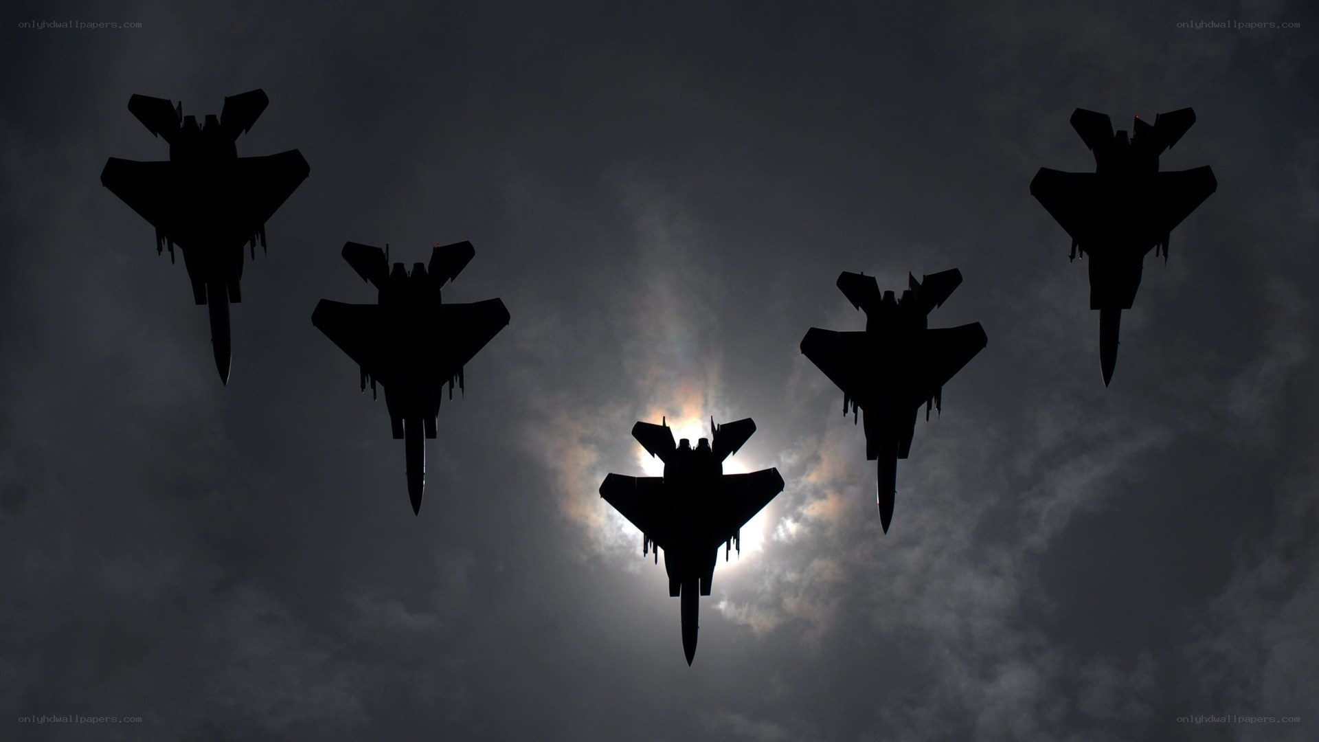 Silhouetted fighter jets in formation