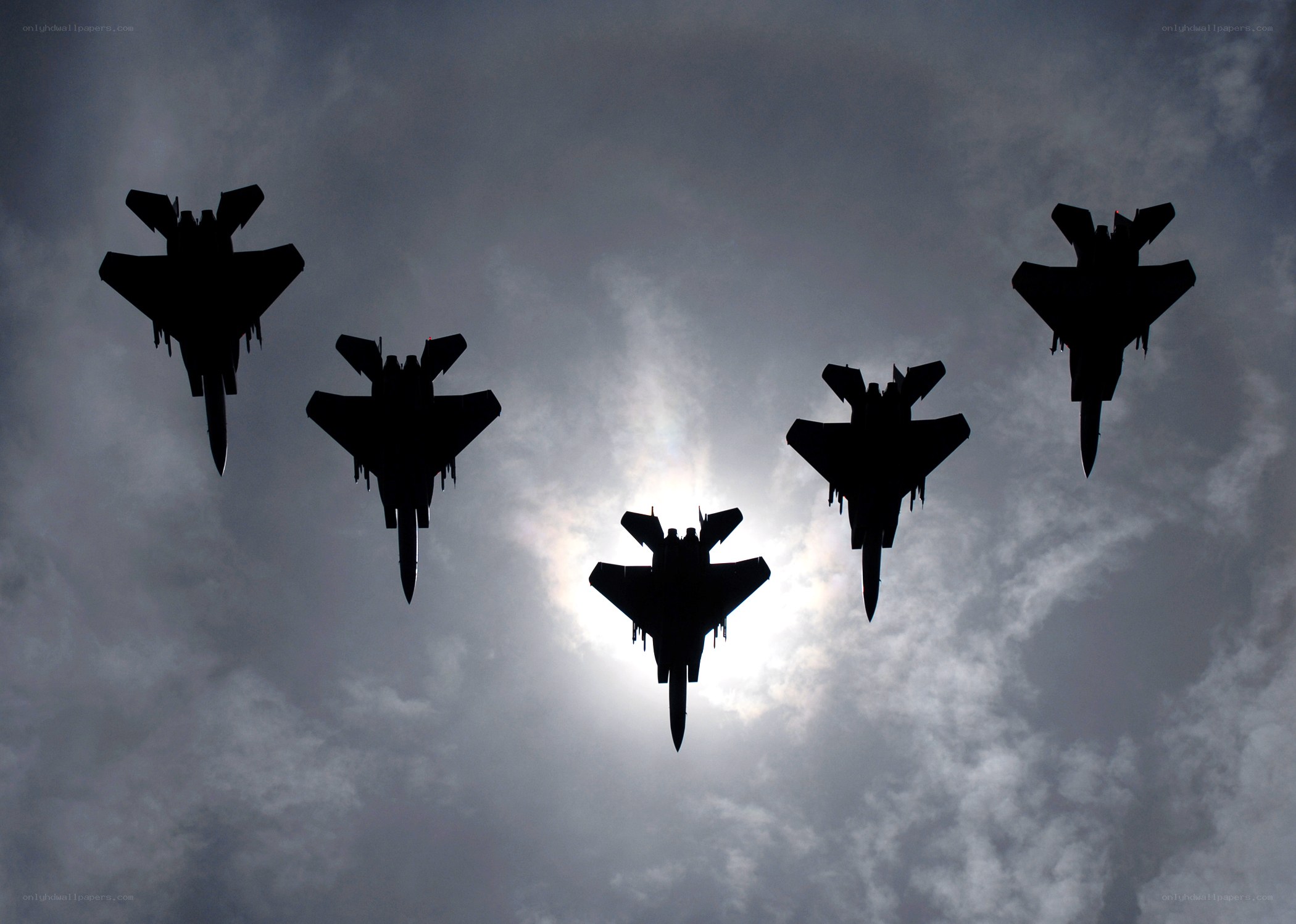 Silhouetted fighter jets in formation