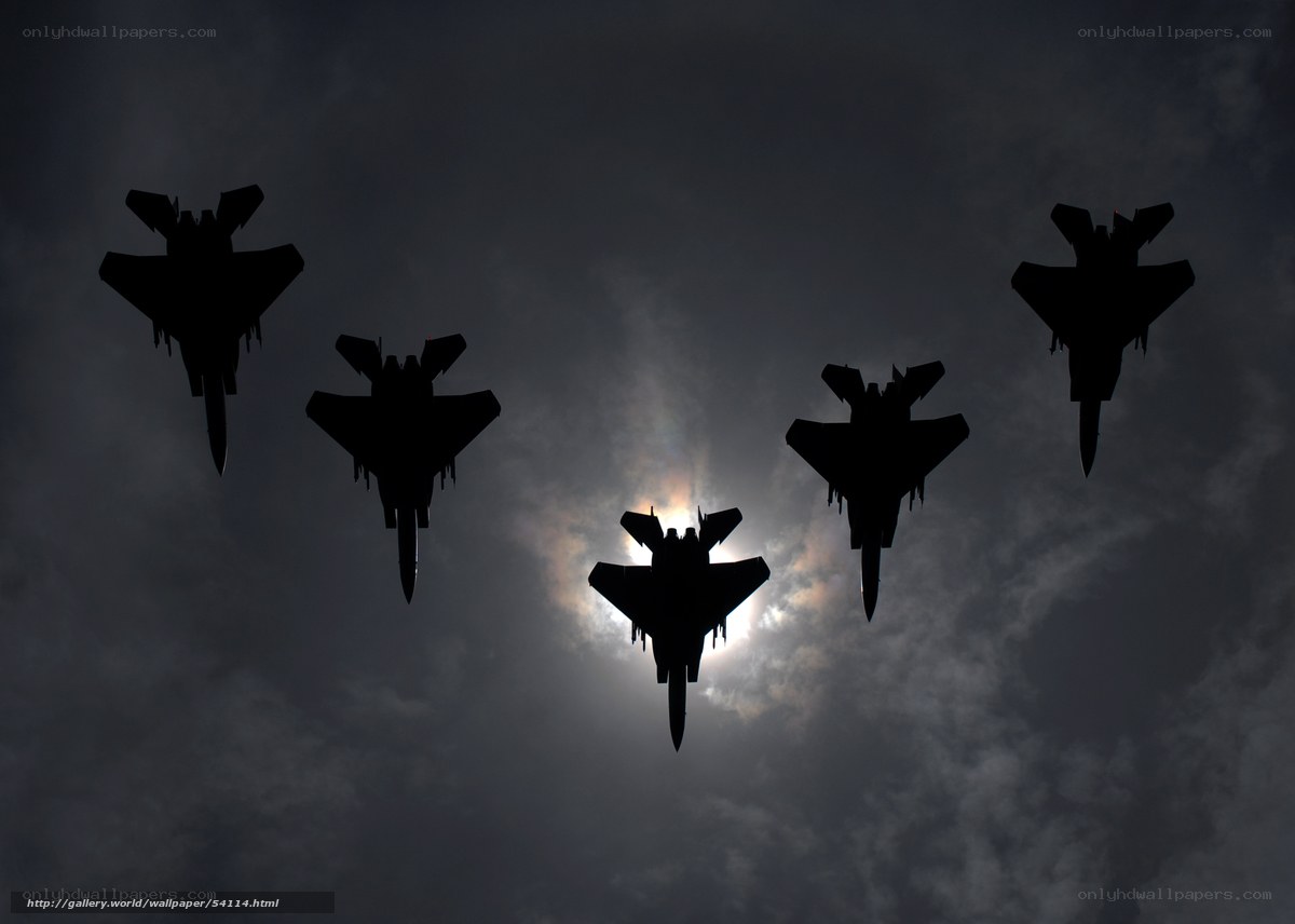 Silhouetted fighter jets in formation