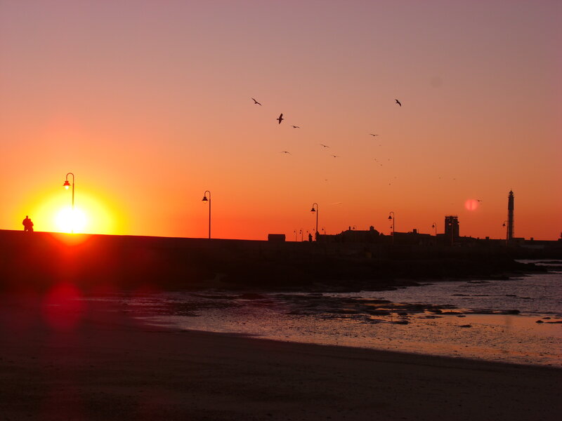Silhouetted Figures on Pier — Orange