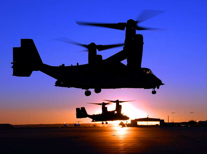 Silhouetted helicopters at sunset