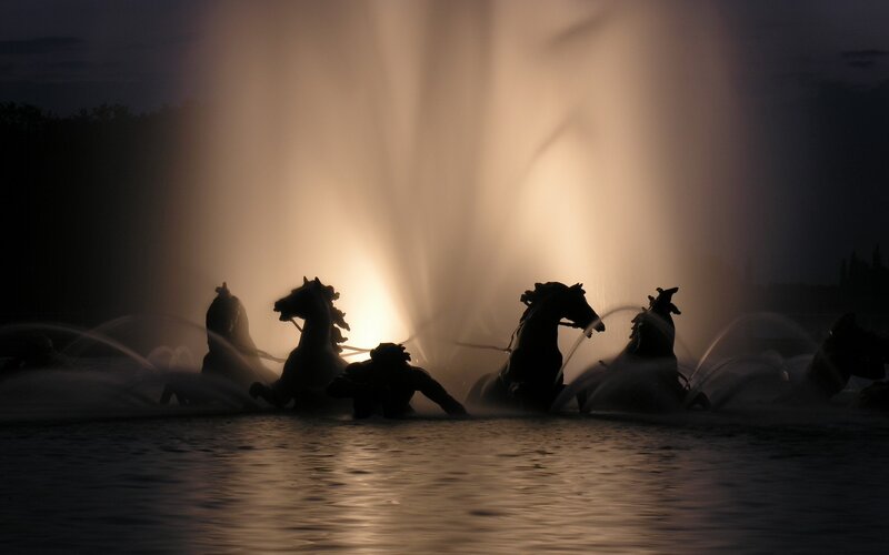 Silhouetted horse fountain at night
