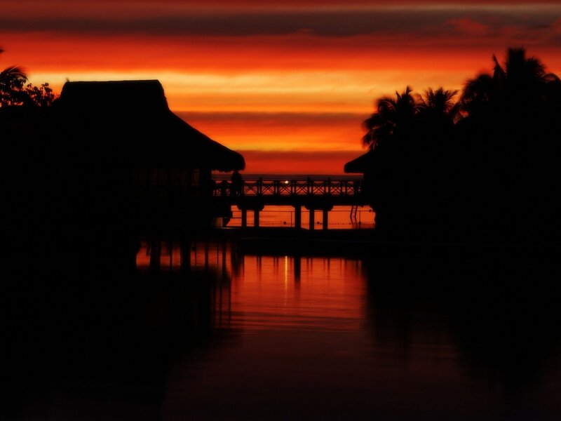 Silhouetted Huts at Sunset