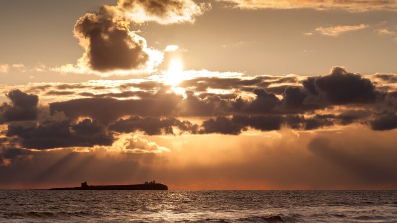 Silhouetted Island at Sunset — Orange, Dramatic, Photograph