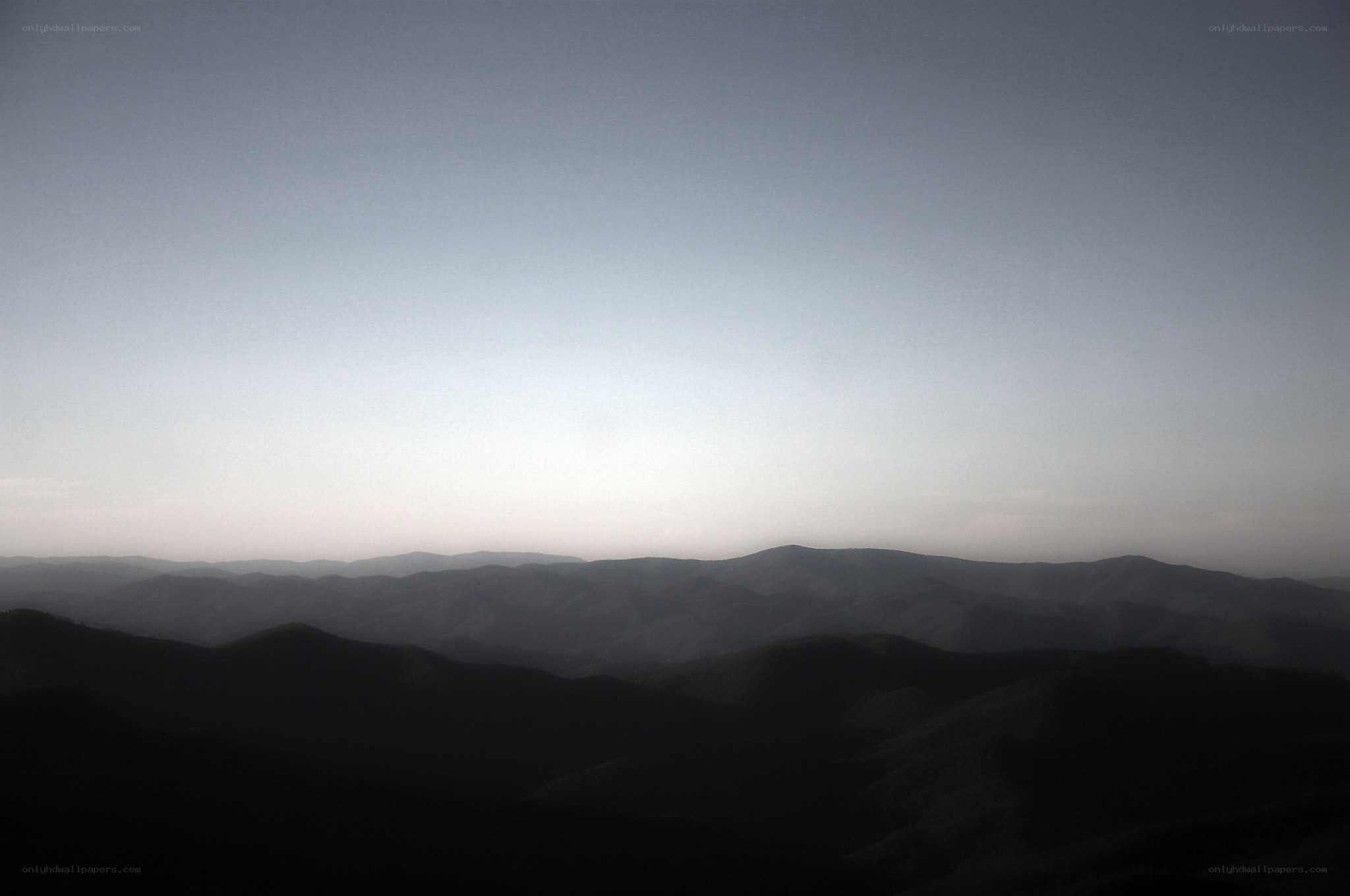 Silhouetted mountain ranges at dawn
