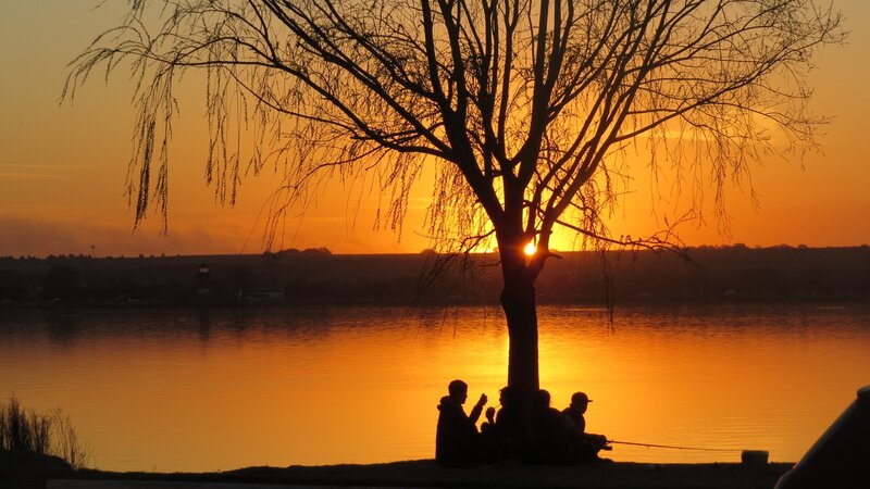 Silhouetted People by Lake — Orange