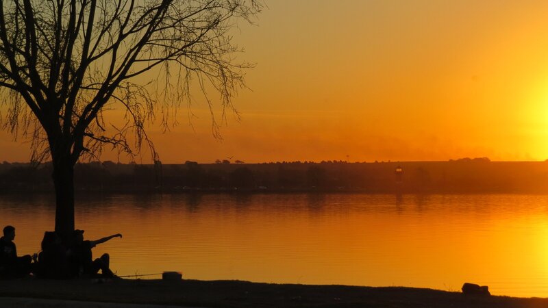 Silhouetted People by Lake