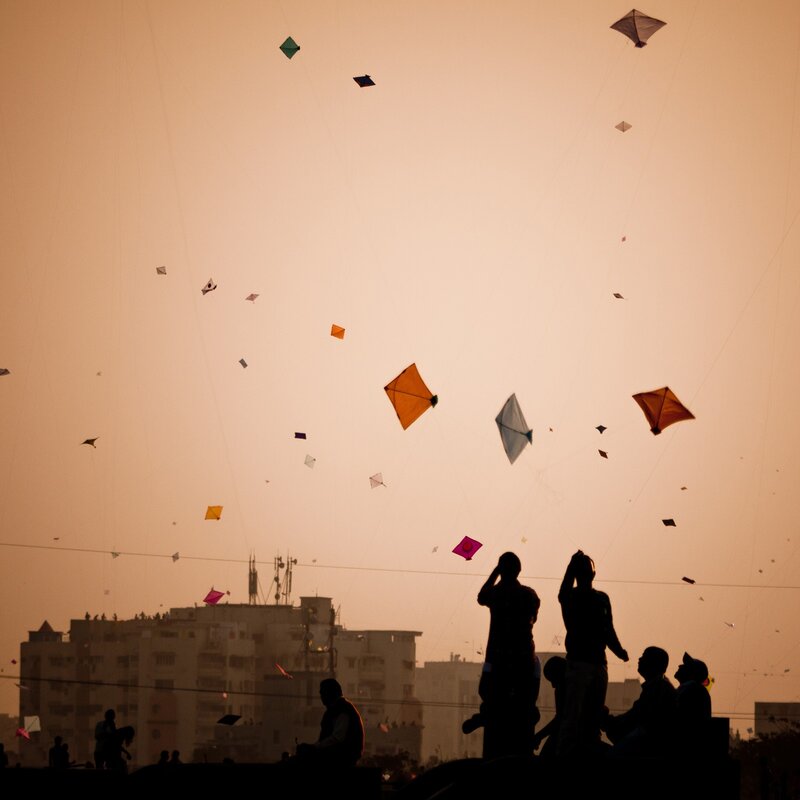 Silhouetted People Flying Kites