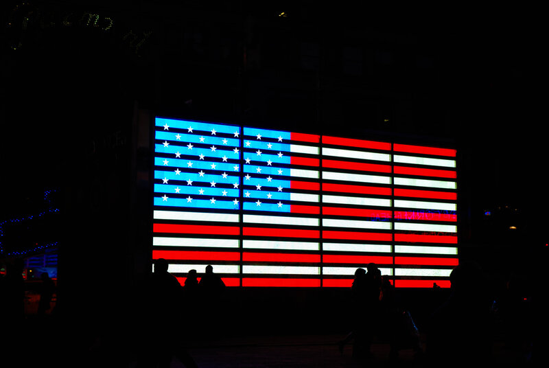 Silhouetted People in Front of Flag