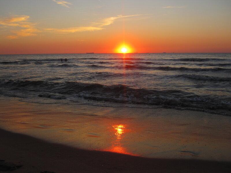 Silhouetted People in Ocean — Orange