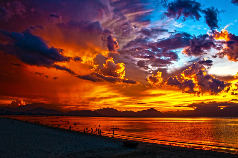 Silhouetted People on Beach — Orange, Dramatic, Sunset, Photograph, Mountains, Clouds