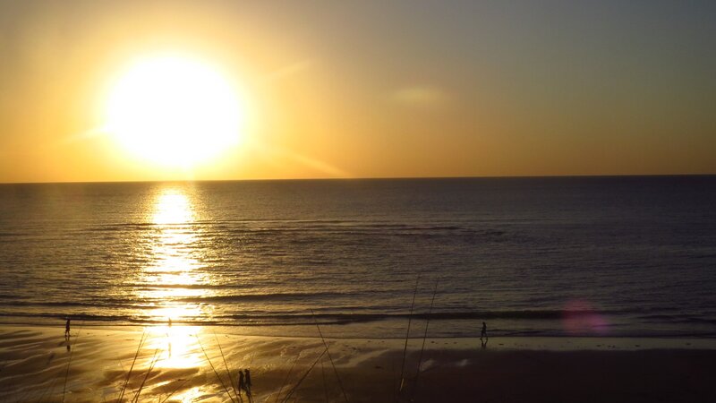 Silhouetted People on Beach — Yellow, Serene, Sunset, Photograph, Sun
