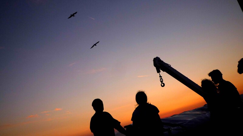 Silhouetted People on Boat