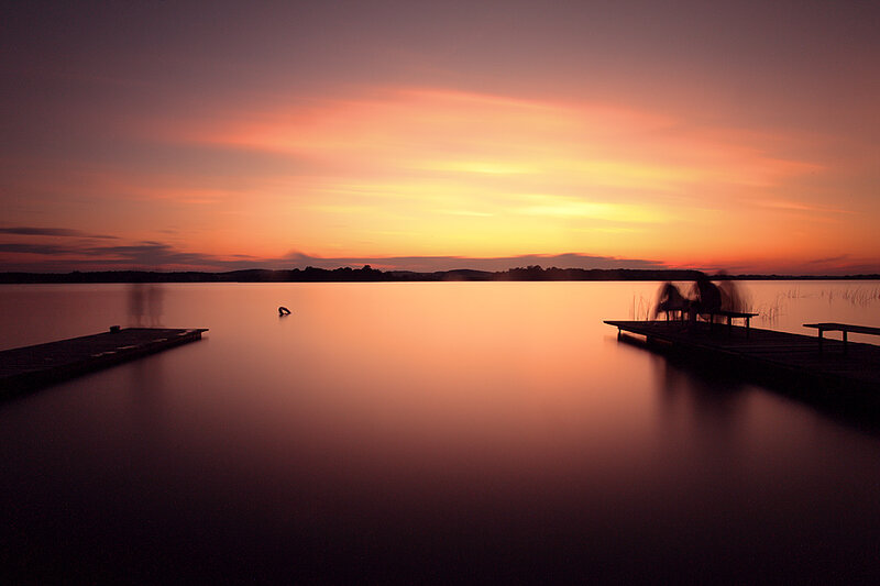 Silhouetted People on Dock — Orange, Serene