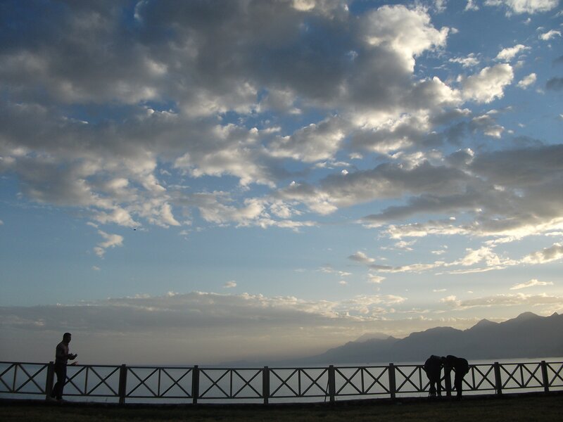 Silhouetted People on Pier — Blue, Serene, Sunset, Photograph, Fence