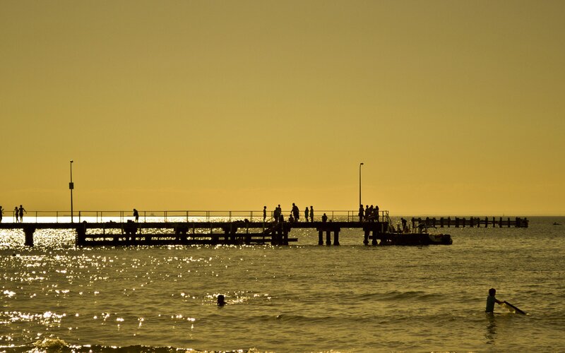 Silhouetted People on Pier — Yellow, Serene