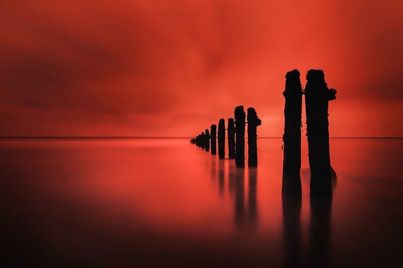 Silhouetted Posts in Water — Red