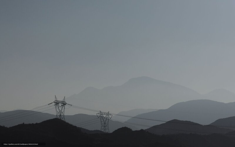 Silhouetted power lines in hazy mountains