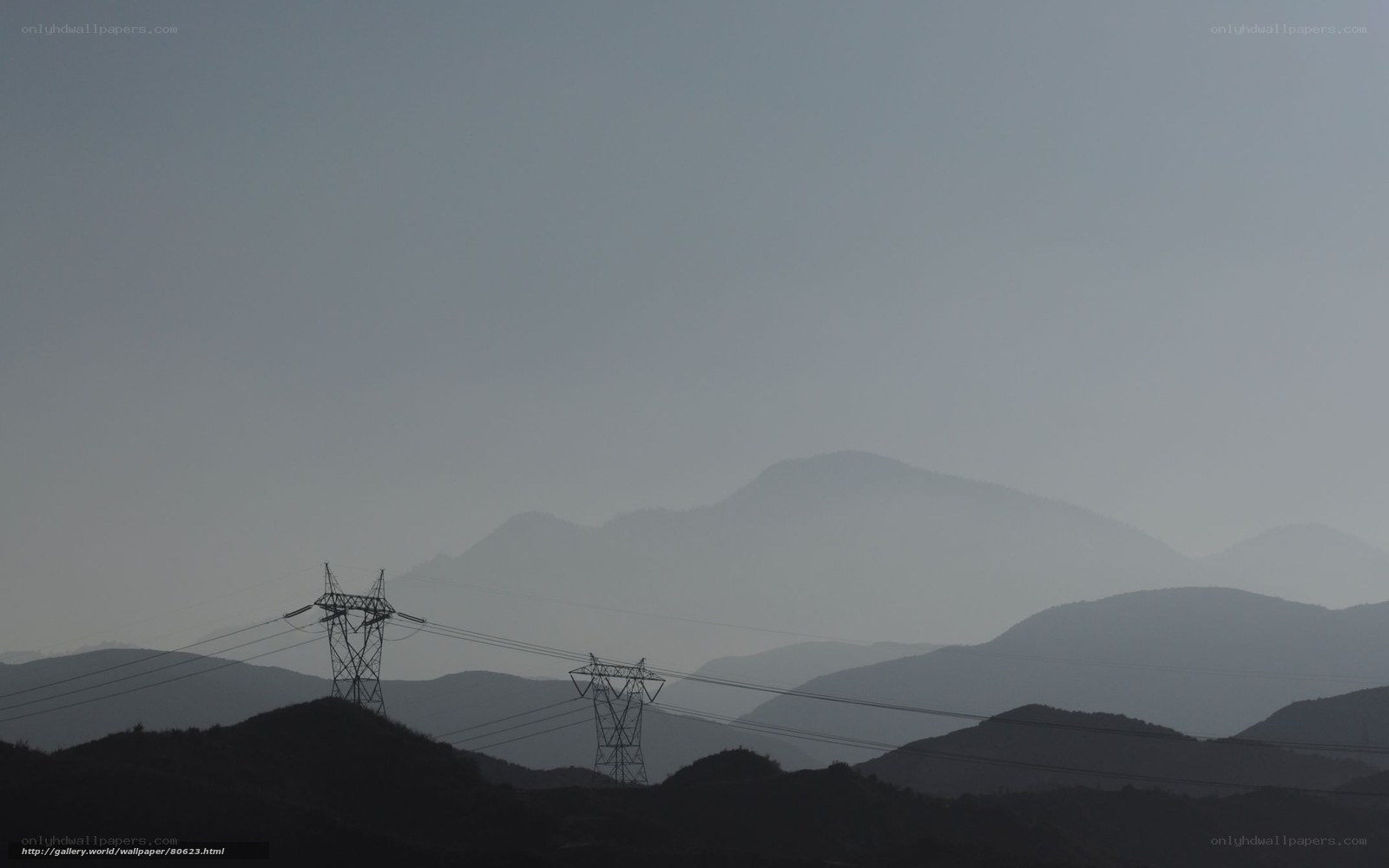 Silhouetted power lines in hazy mountains