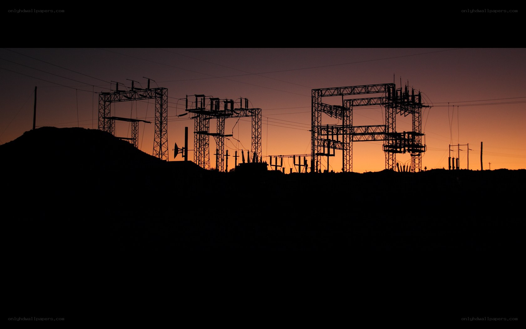 Silhouetted power station at sunset