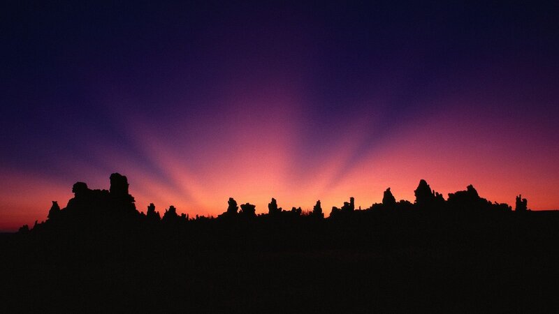 silhouetted rock formations at sunset