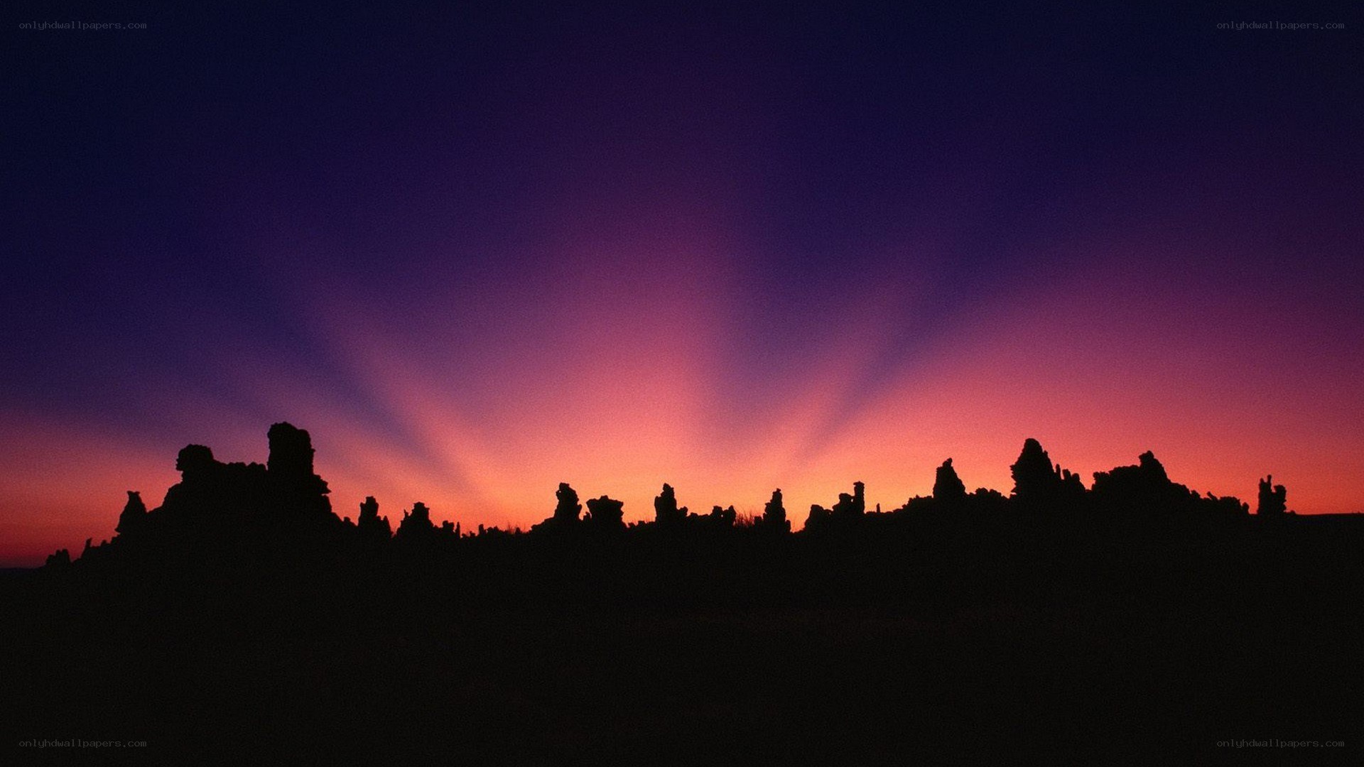 silhouetted rock formations at sunset