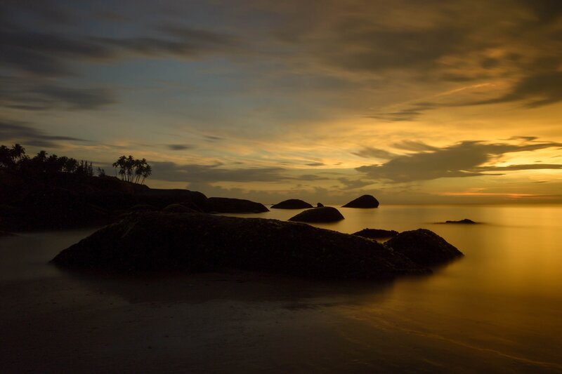 Silhouetted Rocks at Sunset — Gold, Serene, Photograph