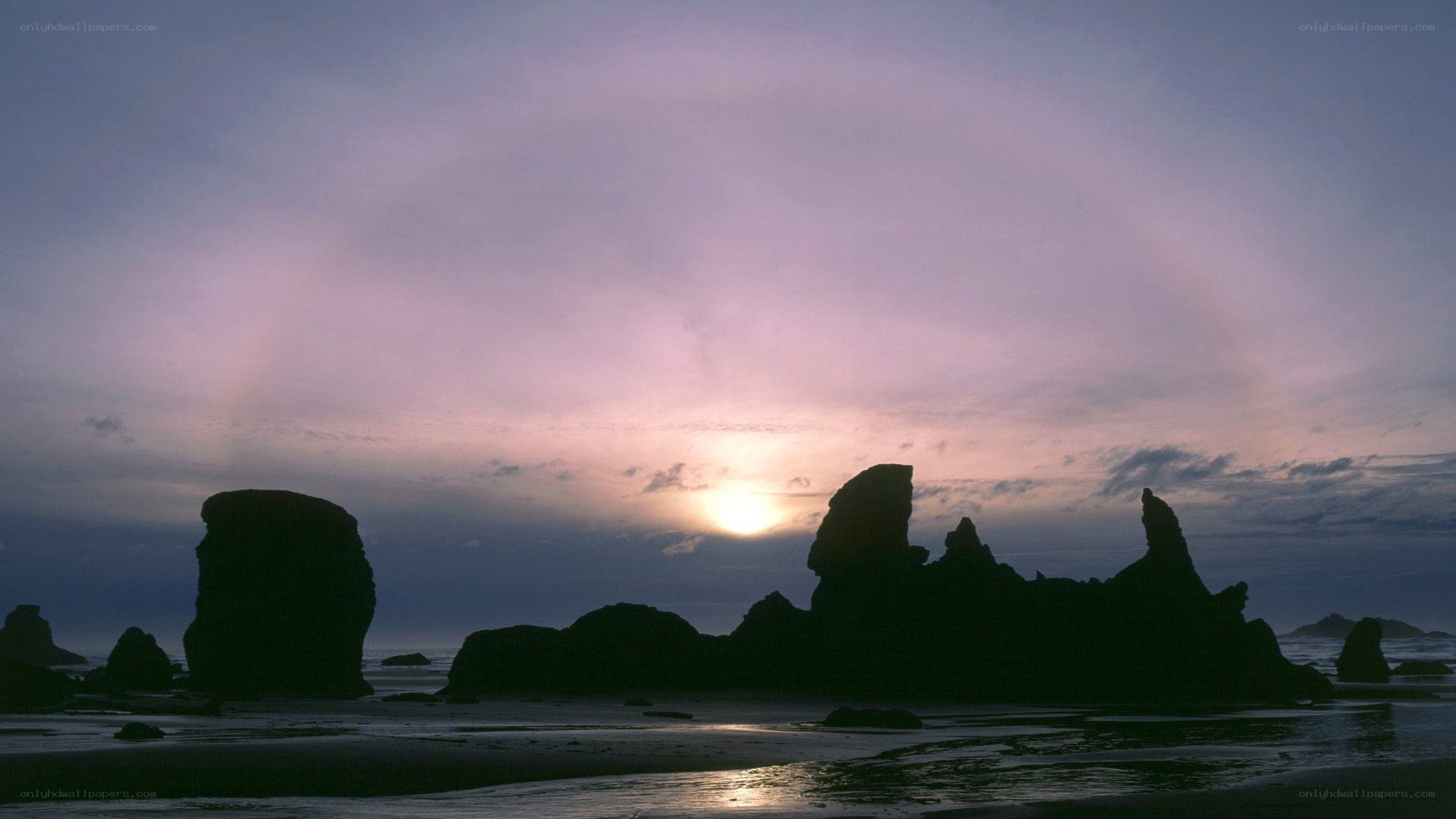 silhouetted sea stacks at sunset